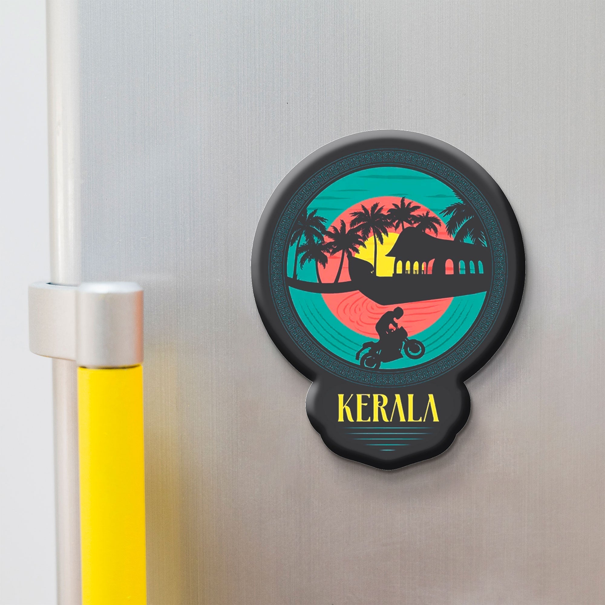 Decorative fridge magnet with 'Kerala' design on a metallic surface